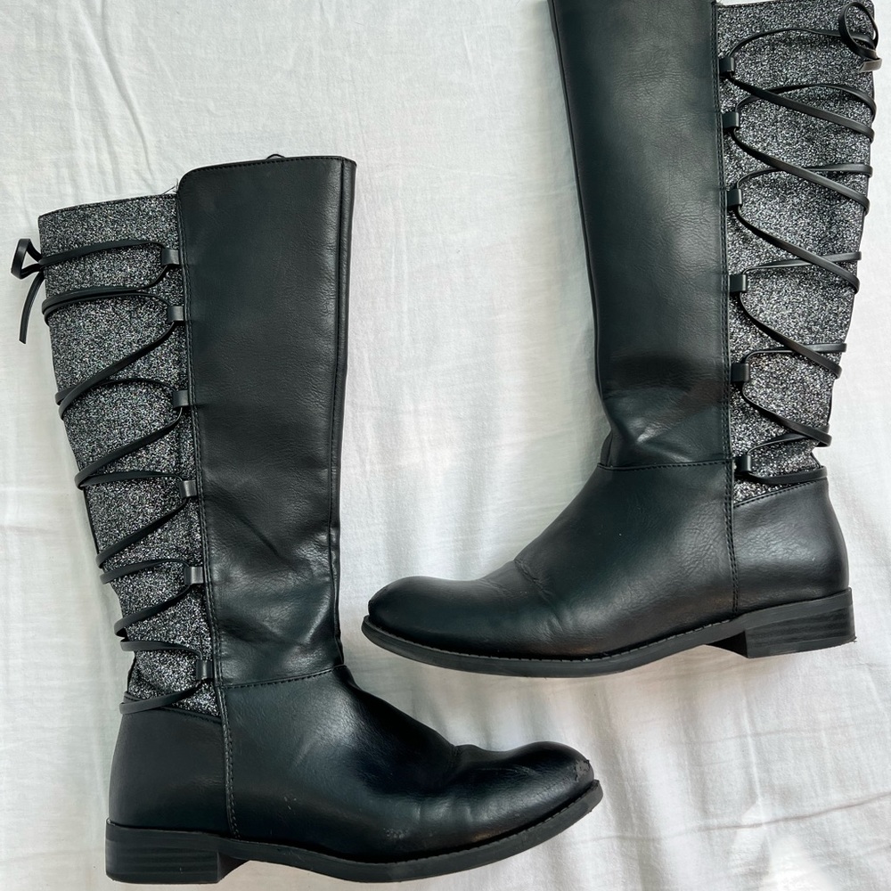 Black boots with a sparkle quality and bow finish.